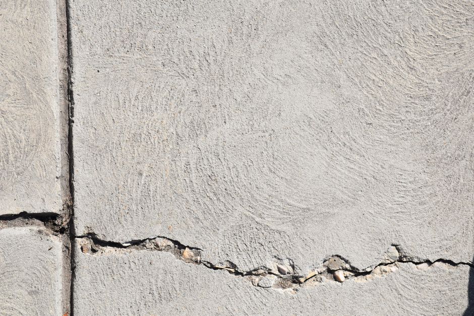 Stap voor stap proces van het herstellen van een betonvloer in een woning, met aandacht voor scheuren en kleurherstel.